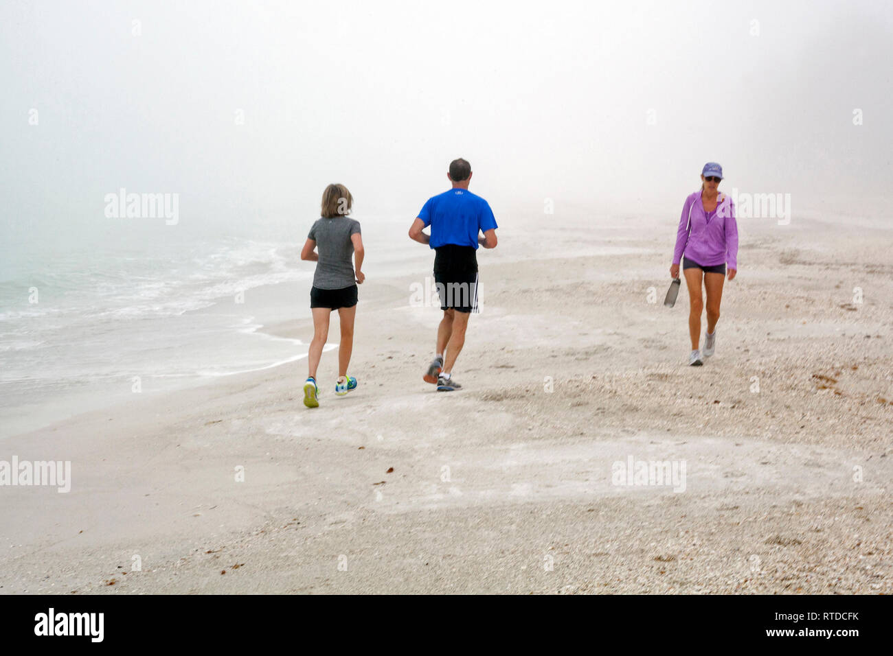 La gente si esercitano in spiaggia su un nebbioso giorno su Anna Maria Island, Florida, Stati Uniti d'America. Foto Stock