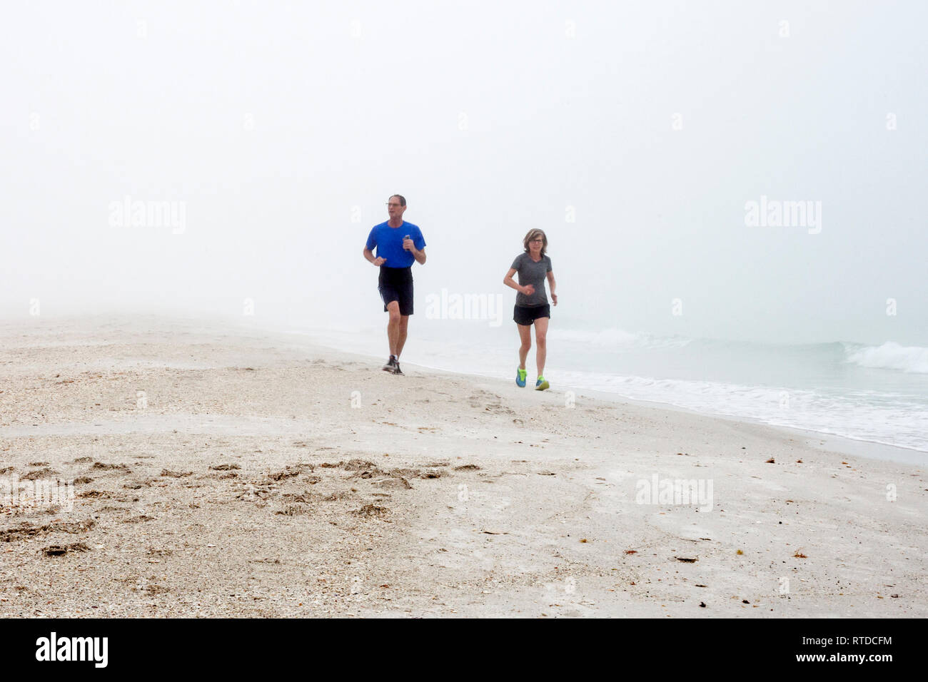 La gente si esercitano in spiaggia su un nebbioso giorno su Anna Maria Island, Florida, Stati Uniti d'America. Foto Stock