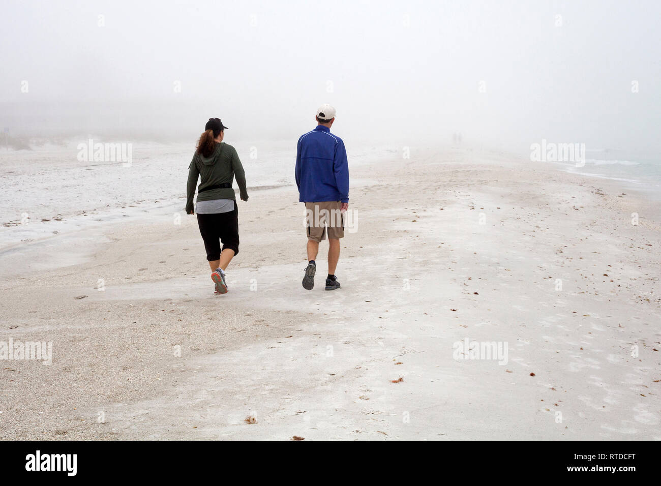 La gente si esercitano in spiaggia su un nebbioso giorno su Anna Maria Island, Florida, Stati Uniti d'America. Foto Stock
