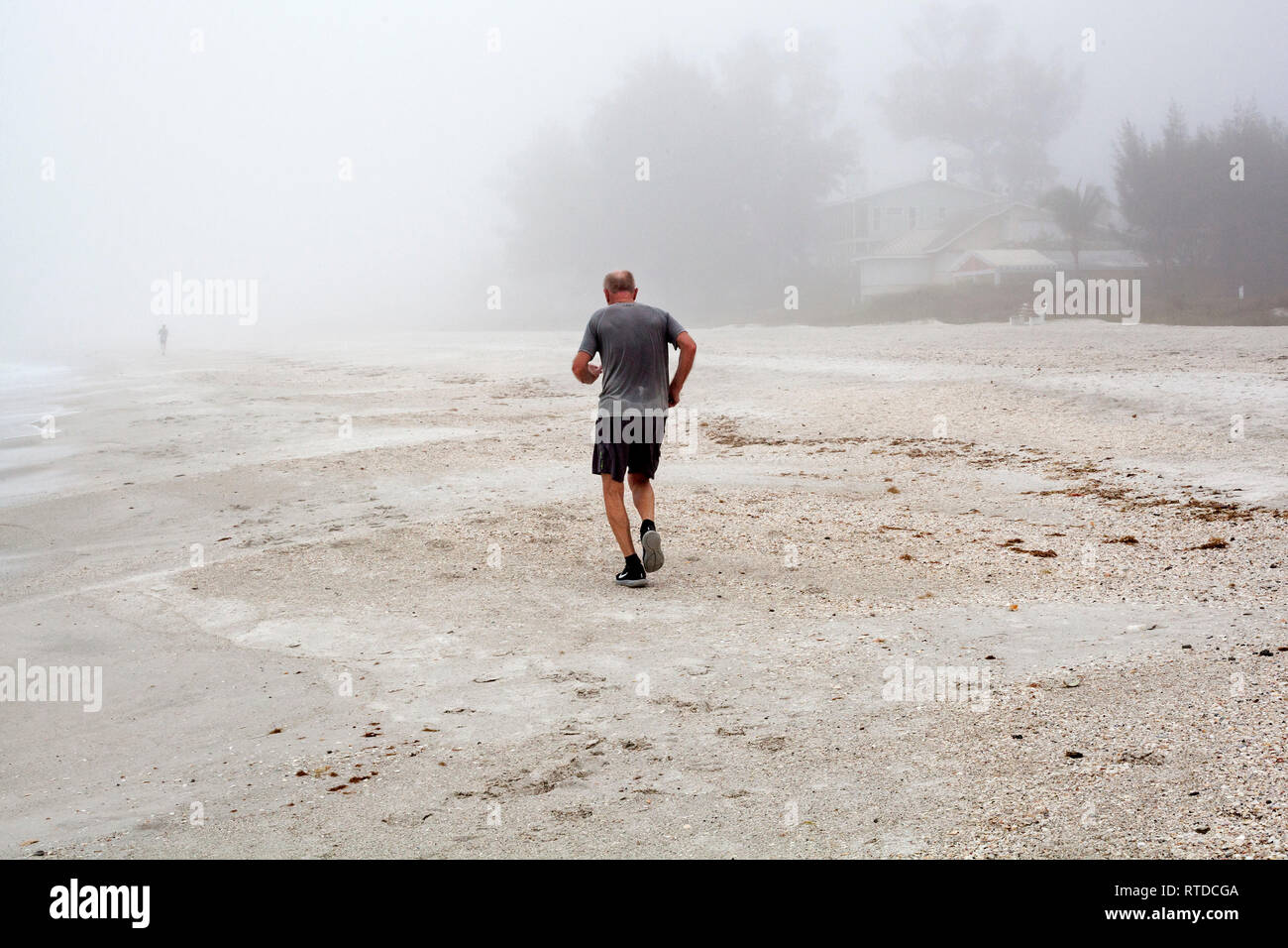 La gente si esercitano in spiaggia su un nebbioso giorno su Anna Maria Island, Florida, Stati Uniti d'America. Foto Stock
