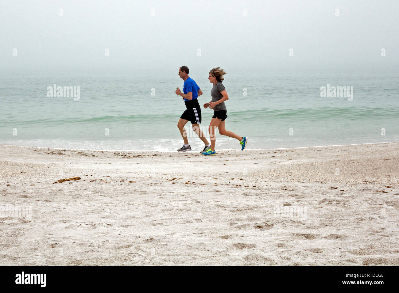 La gente si esercitano in spiaggia su un nebbioso giorno su Anna Maria Island, Florida, Stati Uniti d'America. Foto Stock