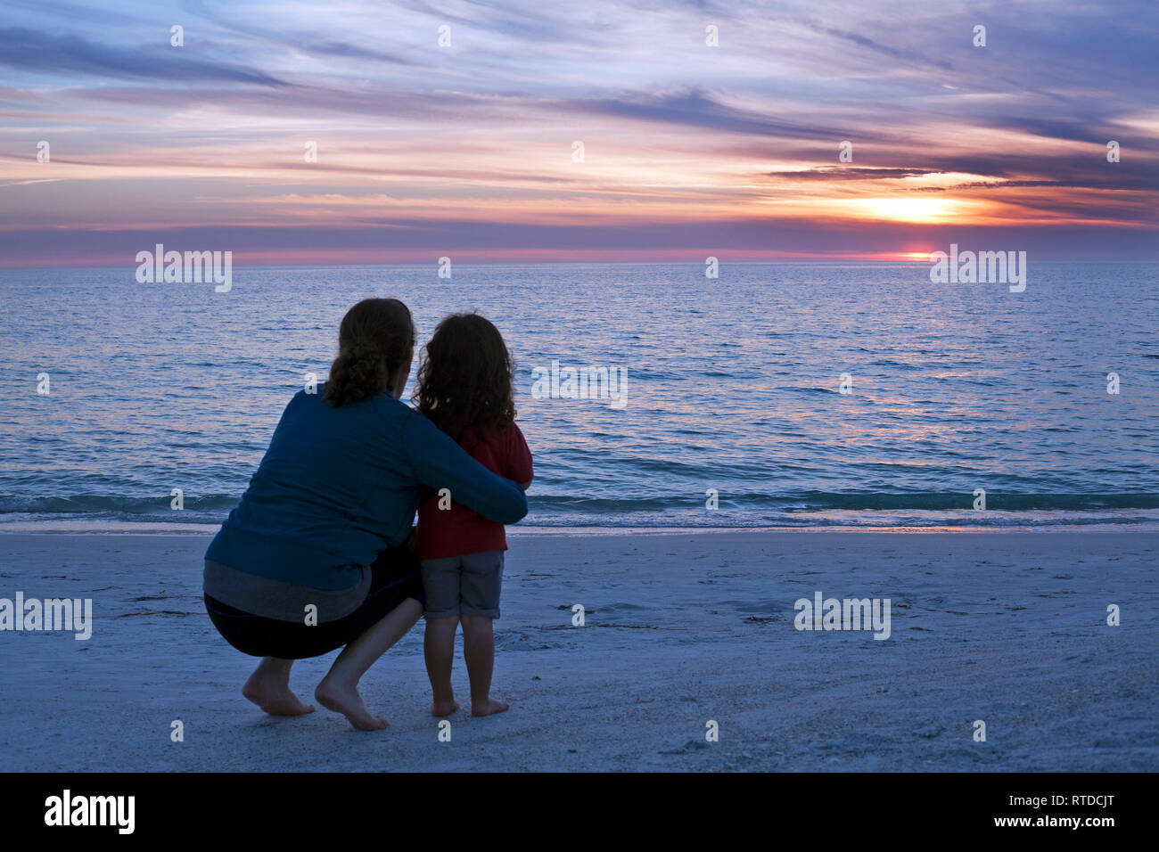 Una madre e un bambino guardare il tramonto sul Golfo del Messico su Anna Maria Island, Florida, Stati Uniti d'America. Foto Stock