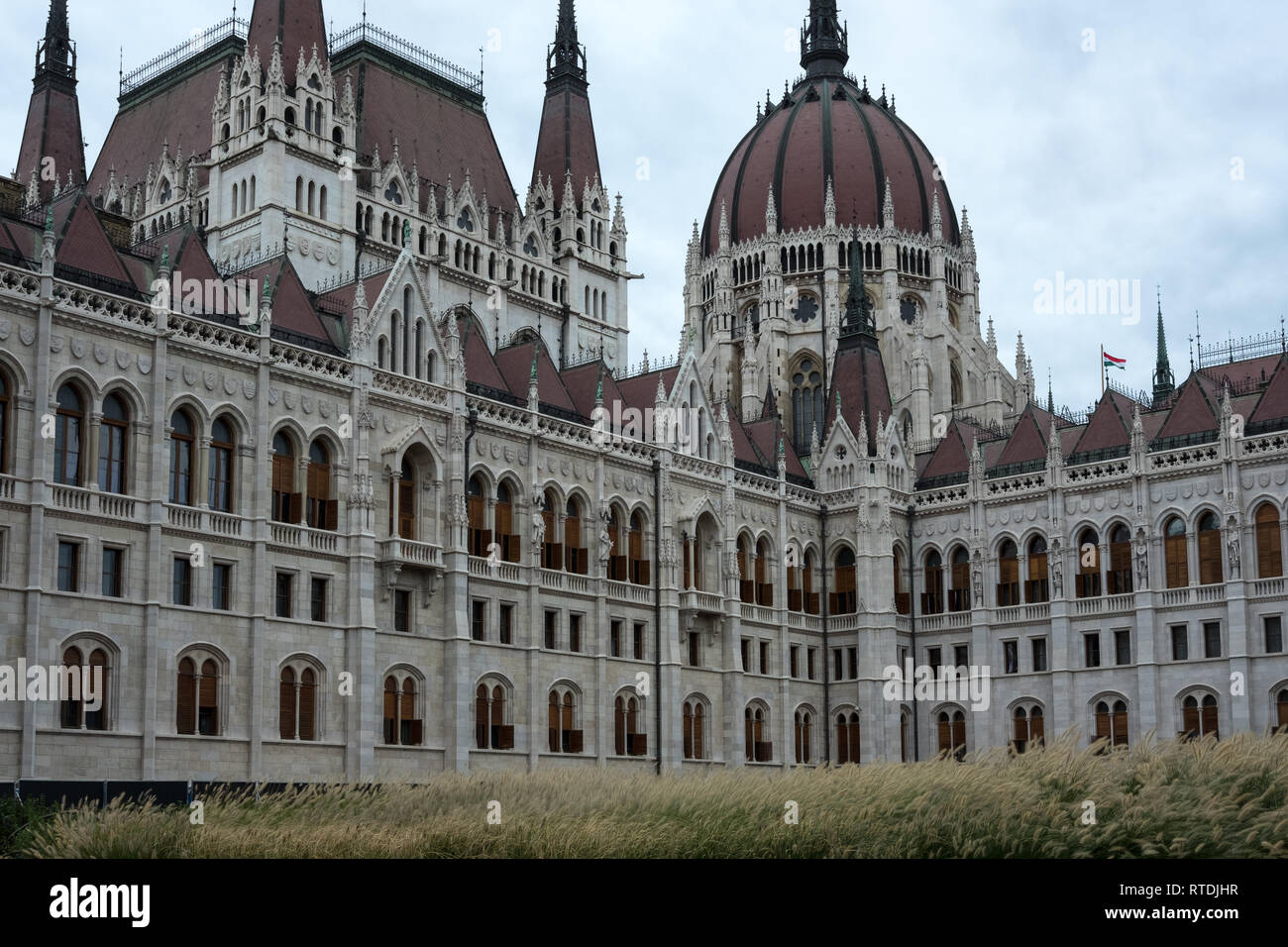Ungherese edificio del Parlamento europeo a Budapest che mostra il dettaglio di architettura e ornamentazione. Piccolo rosso, bianco e verde bandiera ungherese è visibile Foto Stock