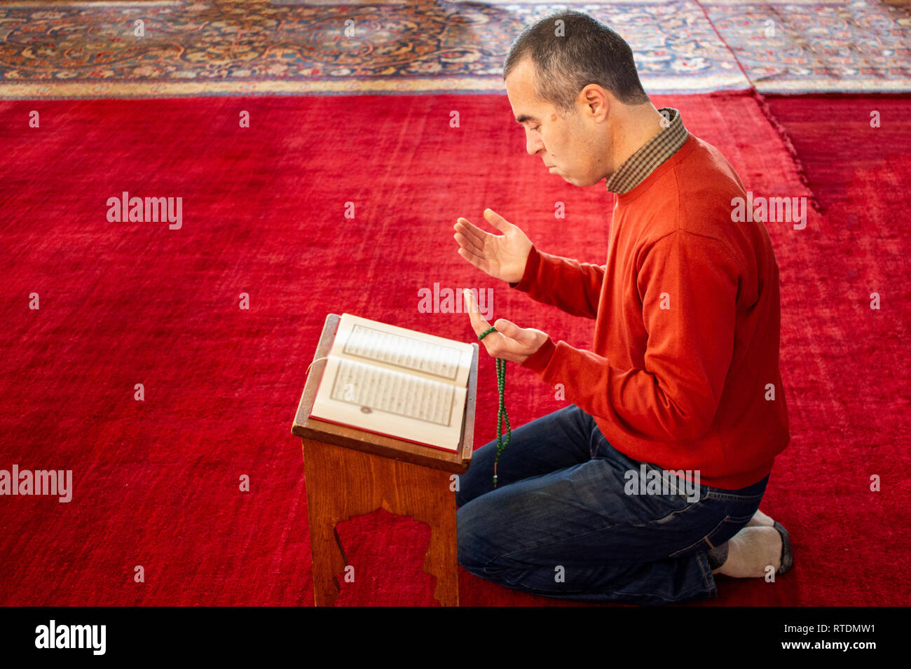 Uomo musulmano per la lettura del Corano alla moschea Foto Stock