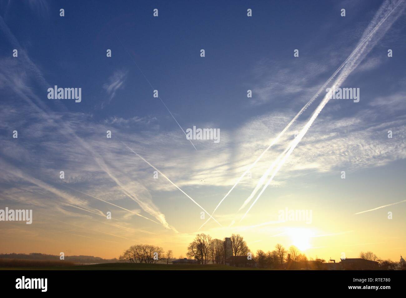 Strisce di codice nel cielo sopra Schleswig al tramonto in serata nel tardo inverno. In teorie cospirative, queste nuvole sottili causati da aerei sono anche indicati come chemtrails. Chemtrail è un portmanteau della chimica in inglese per le sostanze chimiche e per contrails contrails, in tedesco in modo sulle strisce di chimica. | Utilizzo di tutto il mondo Foto Stock