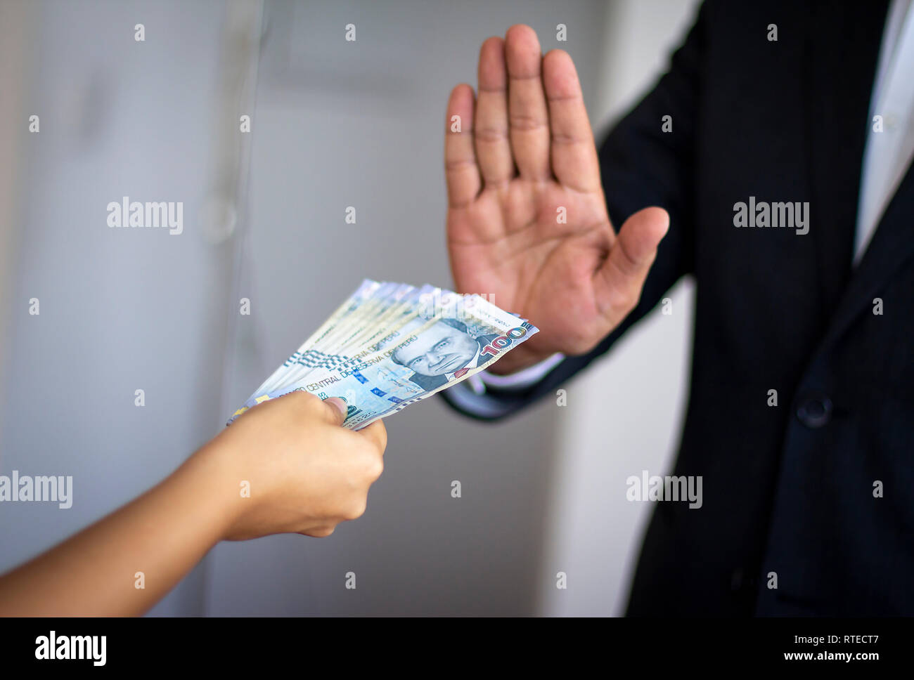 Uomo di rigetto di denaro offerti da una donna, suole peruviano moneta in note di 100 fatture. Anti corruzione concetti. Foto Stock