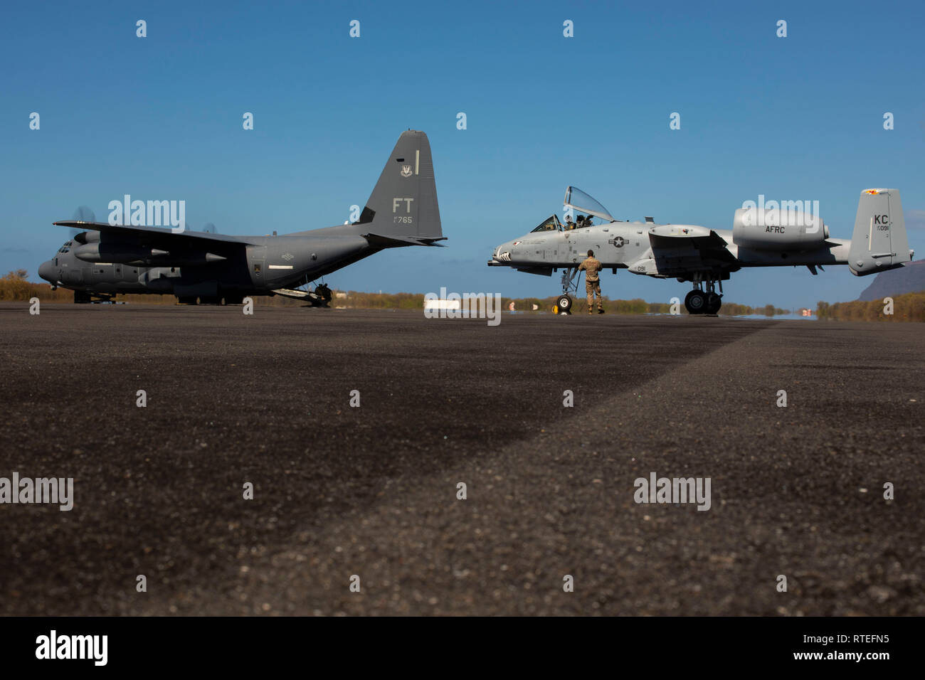 Stati Uniti Air Force C-130 e A-10 Thunderbolt II aeromobili dal 442nd Fighter Wing fuori di Whiteman Air Force Base, Missouri, sono parcheggiate su una pista durante una simulazione di abilitazione di marcia avanti e di punto di rifornimento (FARP) al Pacific Missile Range Facility, Barking Sands, Kauai, Hawaii, Feb 25, 2019. Il FARP viene condotta per migliorare l'unità la capacità di operare in un ambiente austero. (U.S. Marine Corps Foto di Cpl. Brendan Custer) Foto Stock