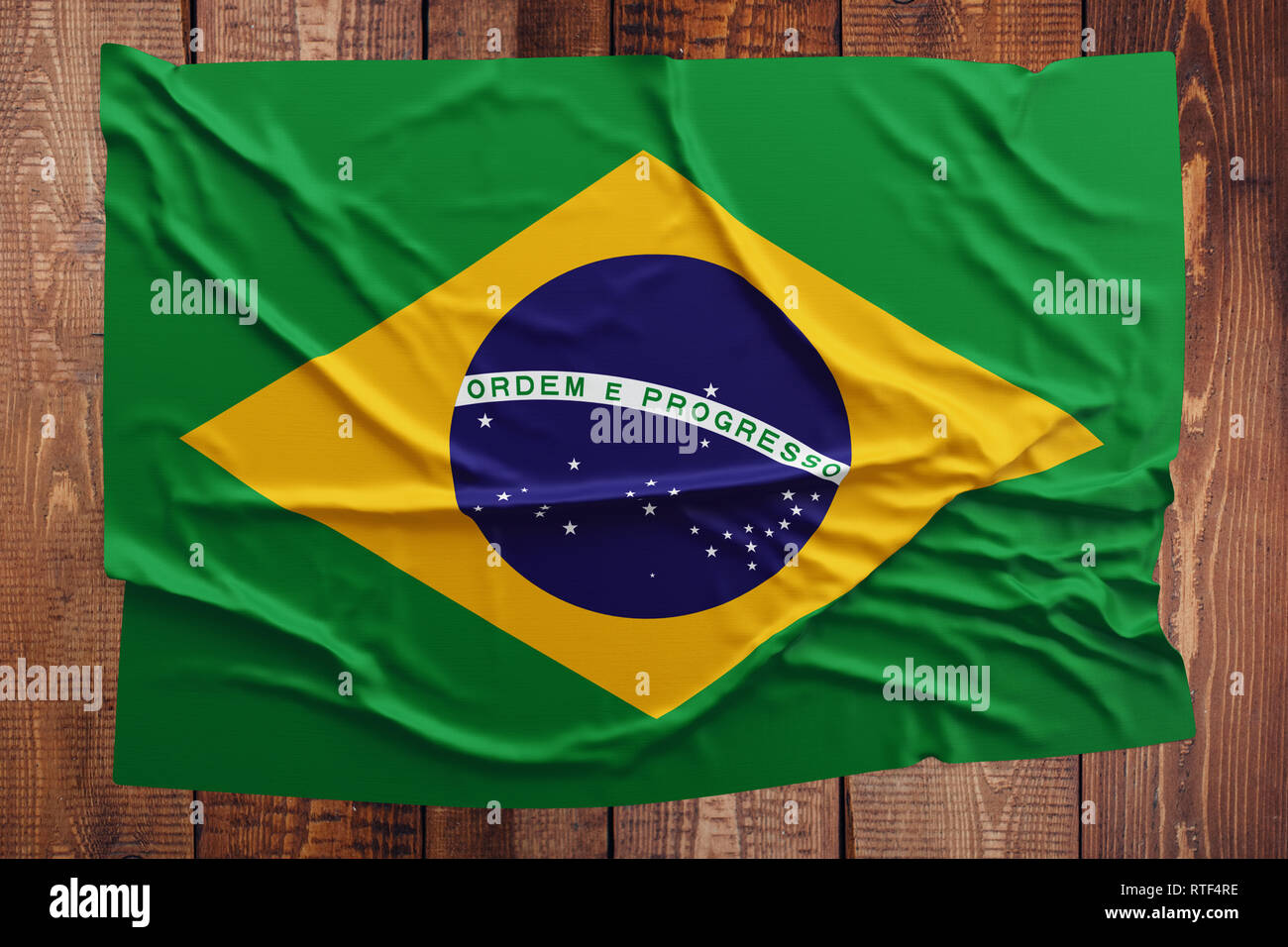 Bandiera del Brasile su una tavola di legno dello sfondo. Stropicciata bandiera brasiliana vista dall'alto. Foto Stock