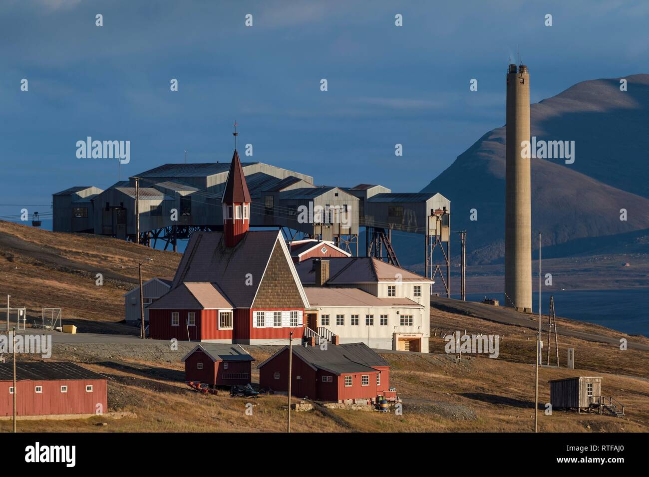 Più settentrionale della Chiesa nel mondo, la Chiesa Svalbard Kirke davanti a un ex miniera di carbone e lo sfiato della centrale a energia termica Foto Stock