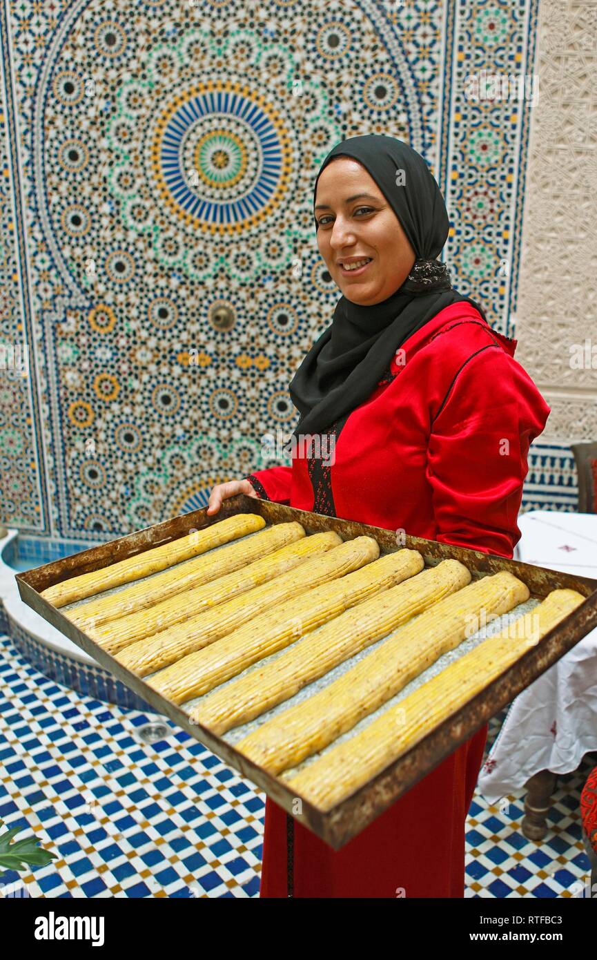 Donna, 30 anni, tenendo un stagno con fekkas, cookie per la cottura, Fès, provincia Fès-Meknès, Marocco Foto Stock