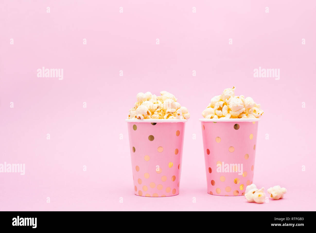 Due tazze di popcorn su un sfondo rosa spazio copia Foto Stock