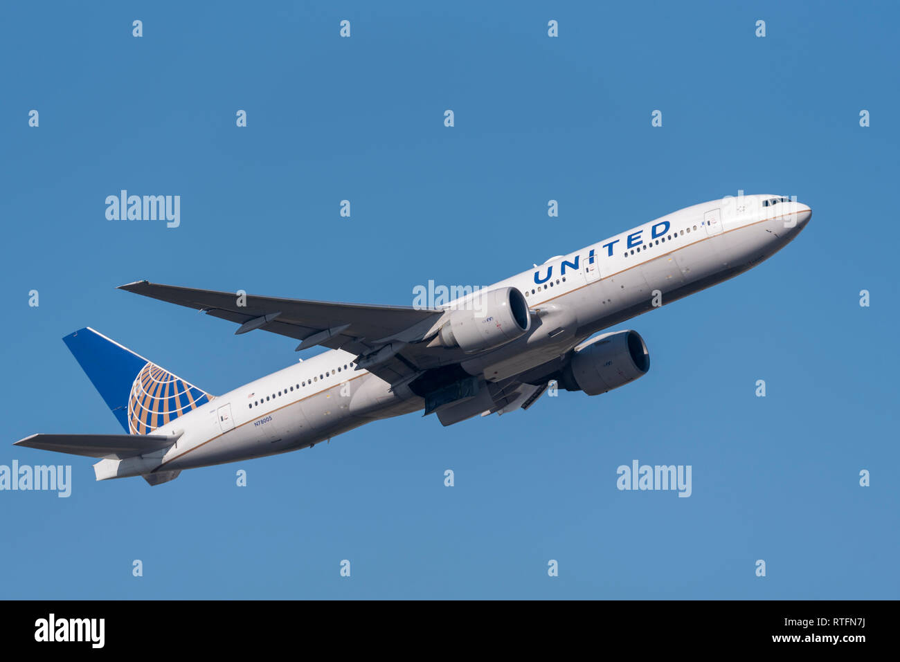 United Airlines Boeing 777 aereo di linea N78005 decolla dall'aeroporto di Londra Heathrow, Regno Unito, in cielo blu. Partenza del volo Foto Stock