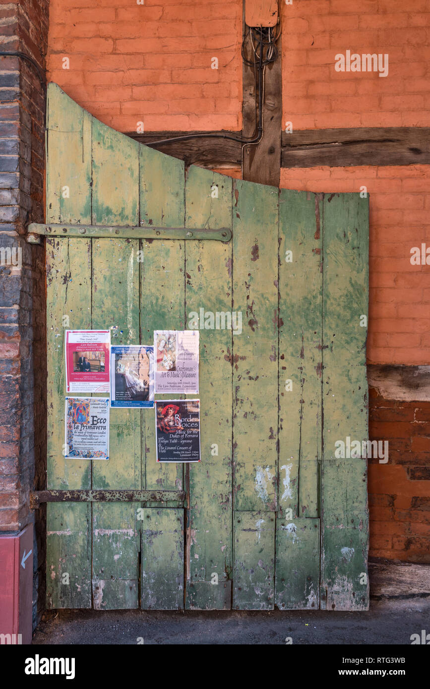 Leominster, Herefordshire, UK. Un vecchio cancello verde contro un color ocra parete in una strada sul retro di questo tranquillo paese di lingua inglese town Foto Stock