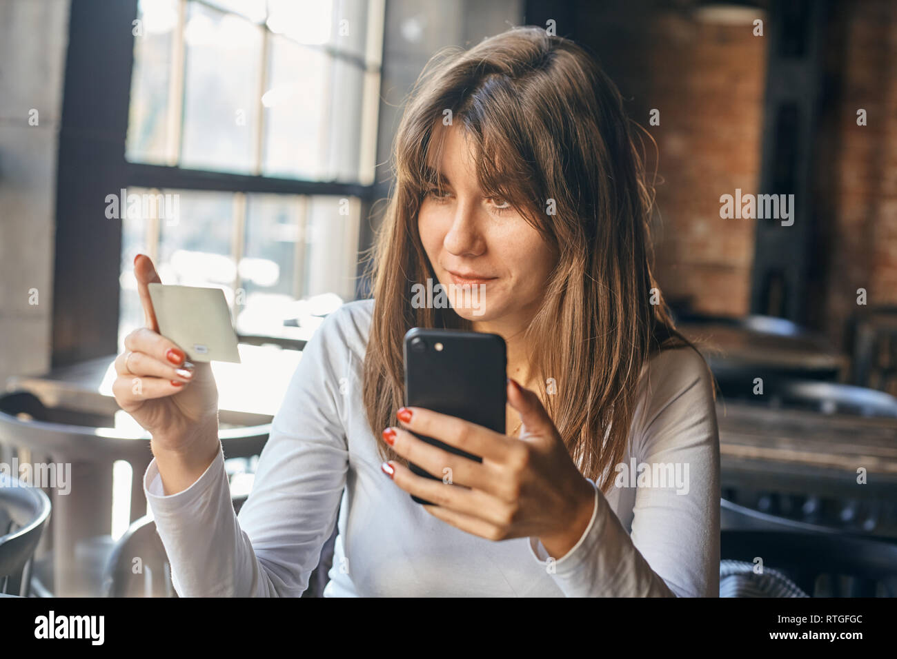 La donna caucasica utilizzando la carta di credito con il cellulare per lo shopping  online in
