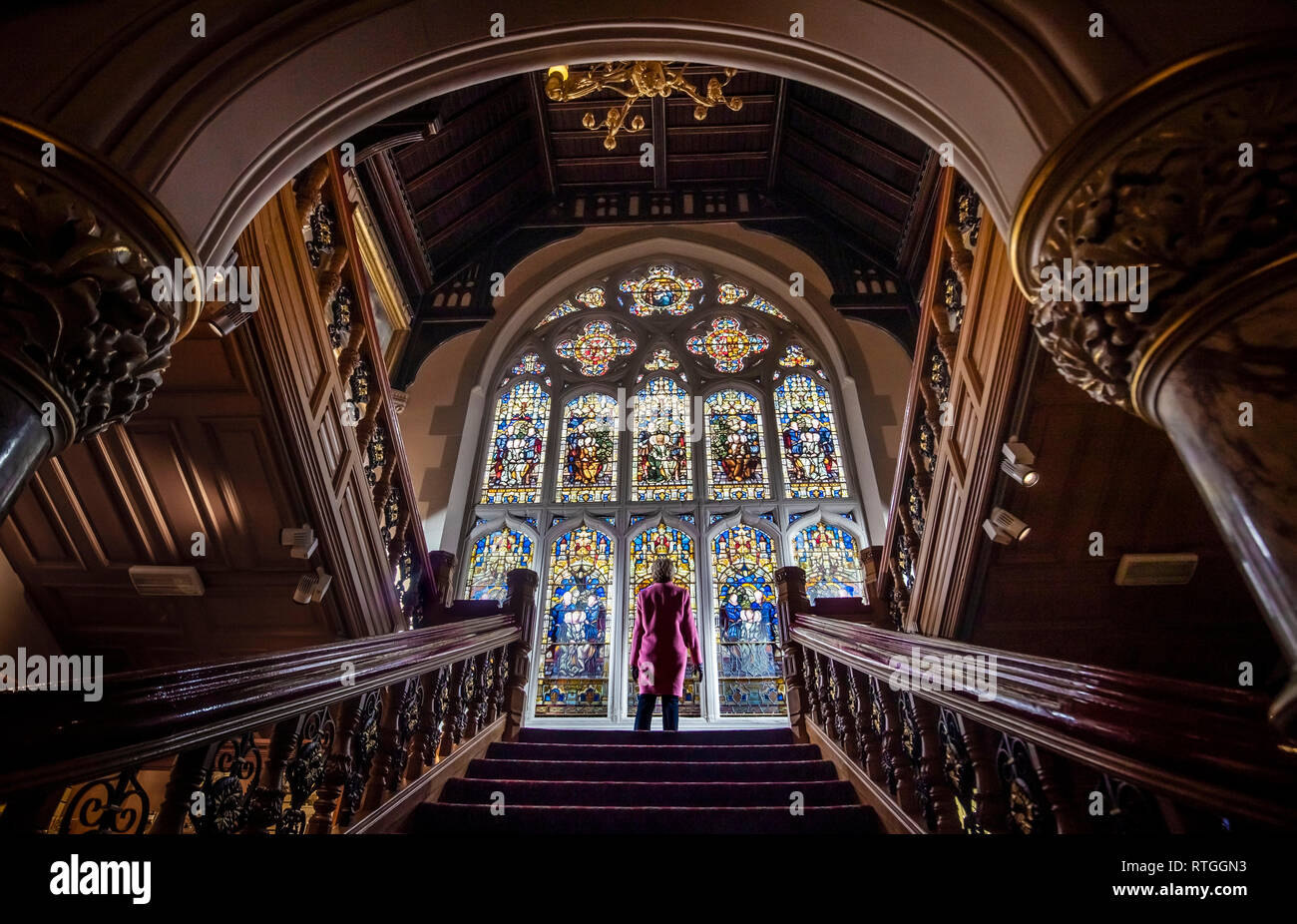 Un membro del pubblico si trova di fronte il recentemente ristrutturato Butterfield finestra a Cliffe Castle a Keighley, nello Yorkshire, a seguito del completamento di una decina di anni di durata del progetto per ripristinare la finestra e scala al castello. Foto Stock