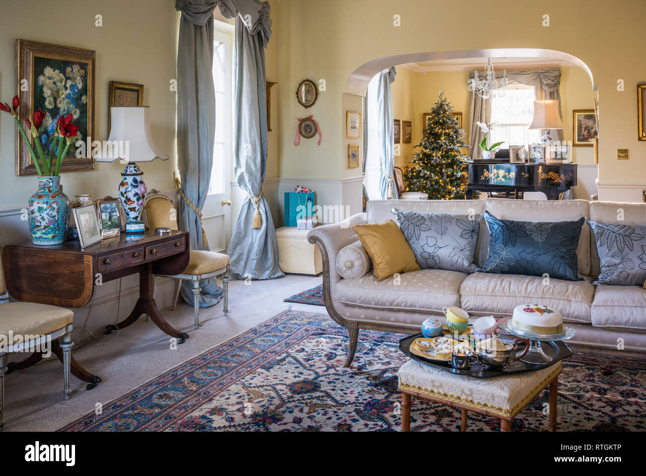 Torta di Natale sul vassoio del tè in camera da disegno con vista attraverso l albero di Natale artificiale e pianoforte acquistato all asta Foto Stock