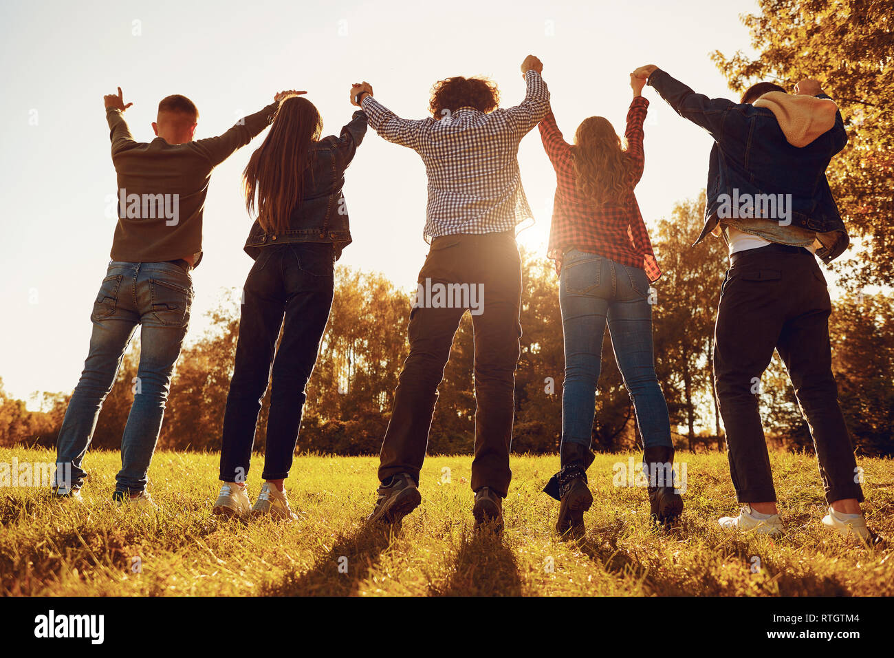 Le persone in piedi con le braccia alzate sul prato Foto Stock