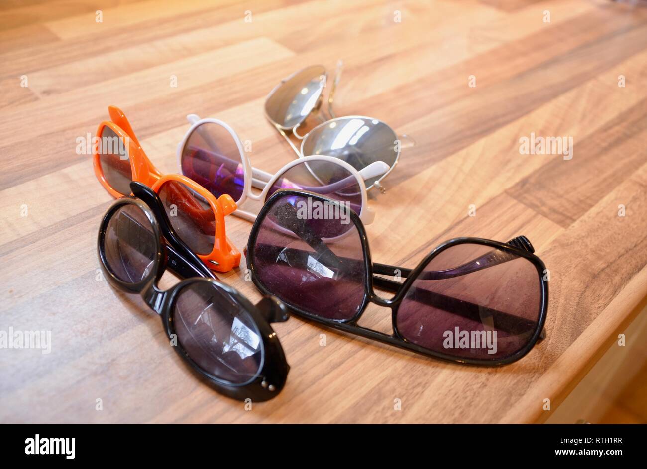 Una collezione di occhiali da sole su di una superficie di lavoro Foto Stock