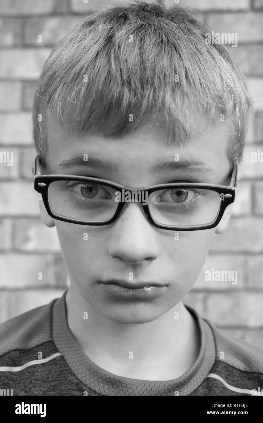 Bianco e nero ritratto di sconvolgere preteen boy con gli occhiali Foto Stock