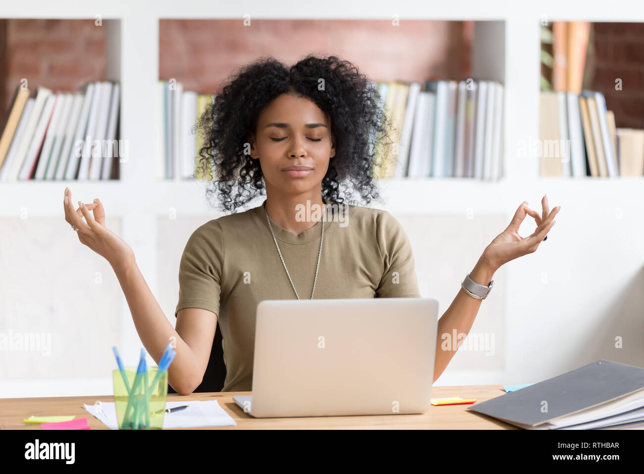 Calma imprenditrice nero facendo rompere meditando a praticare lo yoga al lavoro Foto Stock