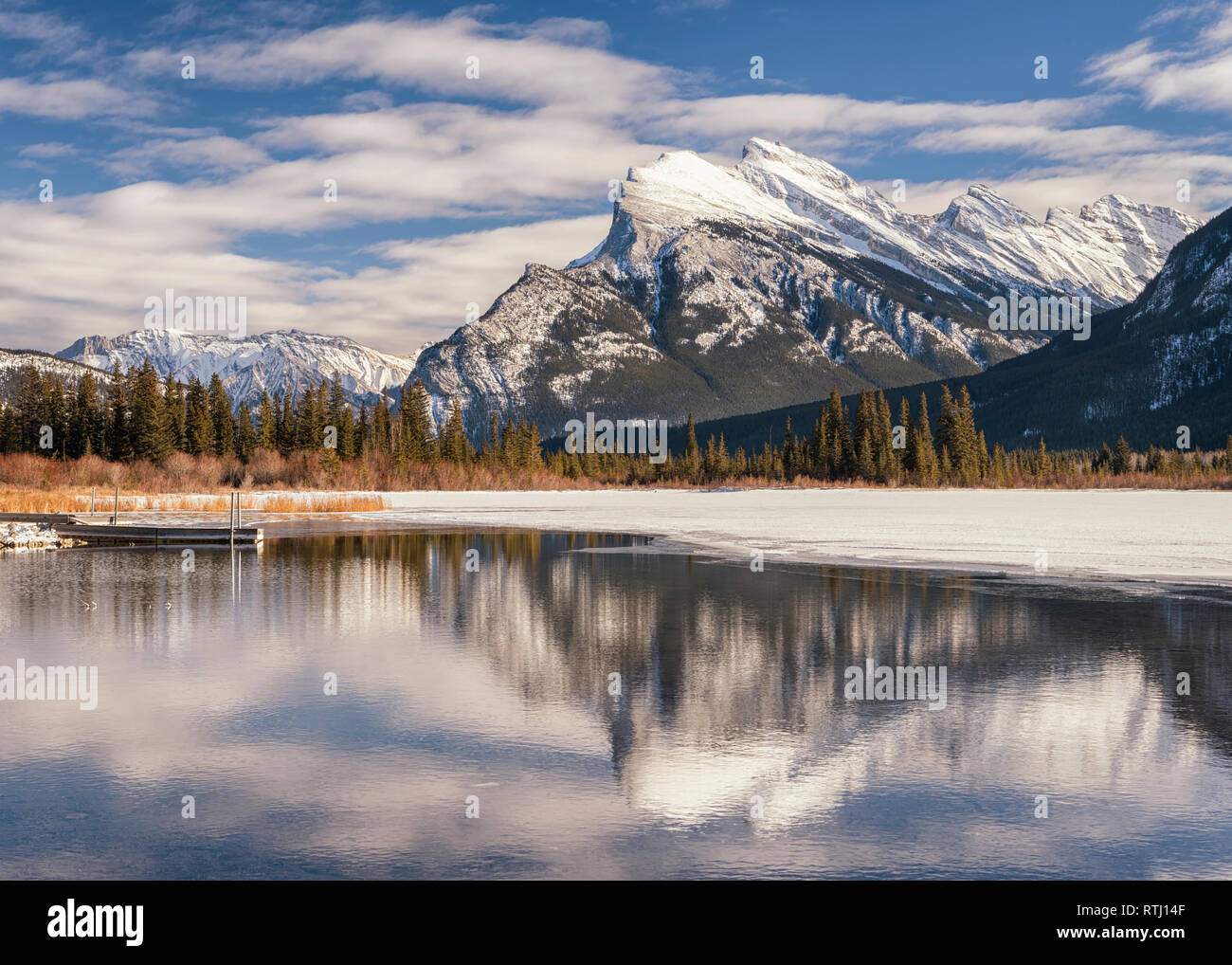 Sunrise a Vermiglio laghi vicino a Banff, Alberta, Canada con le montagne circostanti si riflette nel ghiaccio e acqua. Foto Stock