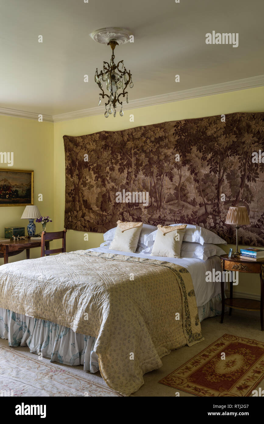 Panno giallo sul letto matrimoniale con montaggio a parete della scena di bosco Foto Stock