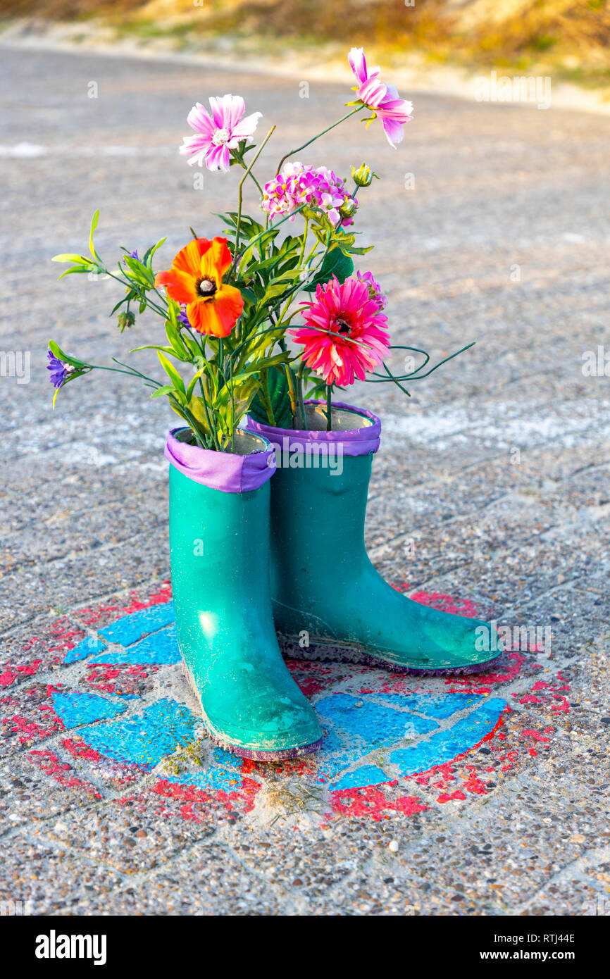 Isola del Mare del Nord Langeoog, Frisia orientale, Bassa Sassonia, stivali  con fiori, decorazione, arte azione, su una spiaggia, fiori in stivali di  gomma Foto stock - Alamy