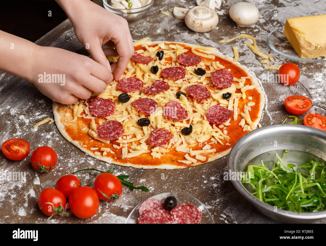 Pizza art. Lo Chef decorare la pizza con vari ingredienti Foto Stock