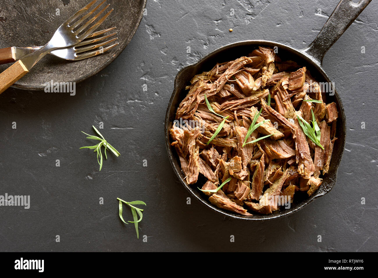 Estratto di carne bovina per i panini in padella sulla pietra nera dello sfondo. Vista superiore Foto Stock