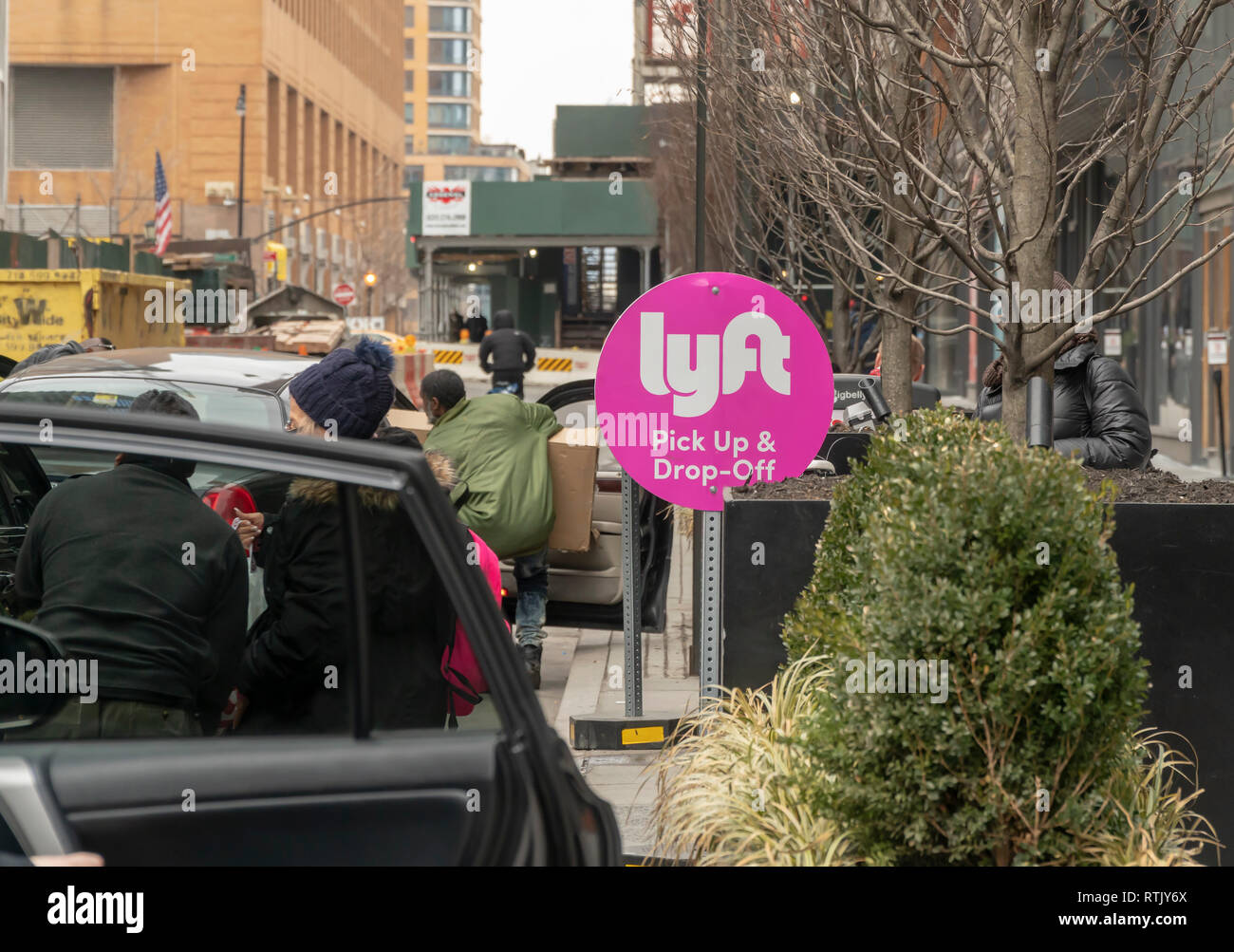 I viaggiatori carico fino in livrea con i loro acquisti al di fuori della città Point Mall nel centro di Brooklyn a New York a un punto designato come un Lyft prelevamento e riaccompagnamento ubicazione sabato 23 febbraio, 2019. L'IPO per la corsa il servizio di condivisione è segnalato per essere vicino come il mese prossimo. (Â© Richard B. Levine) Foto Stock