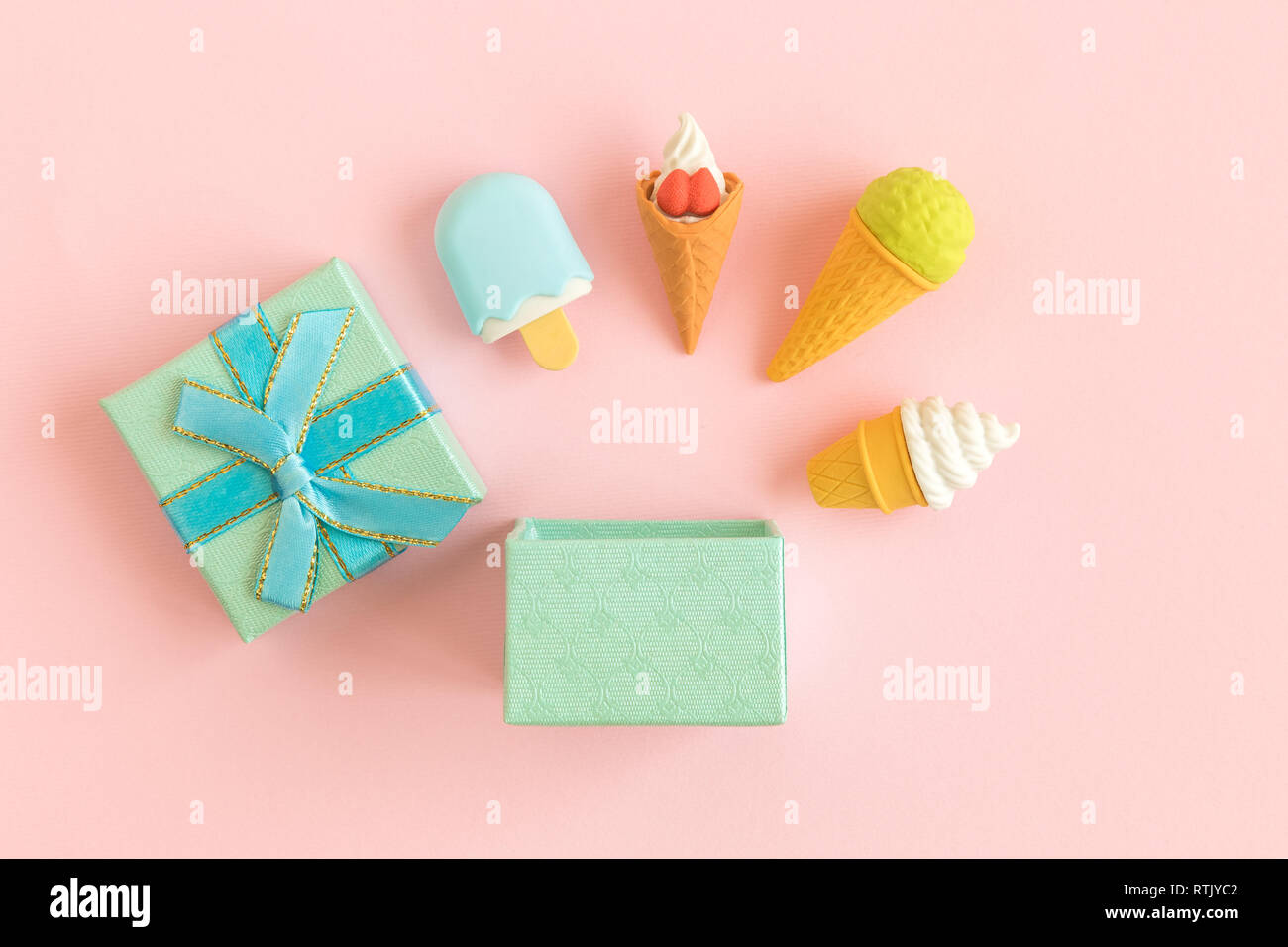 Confezione regalo e diversi tipi di gelato contro di rosa pastello minimo background creativo il concetto di cibo. Foto Stock