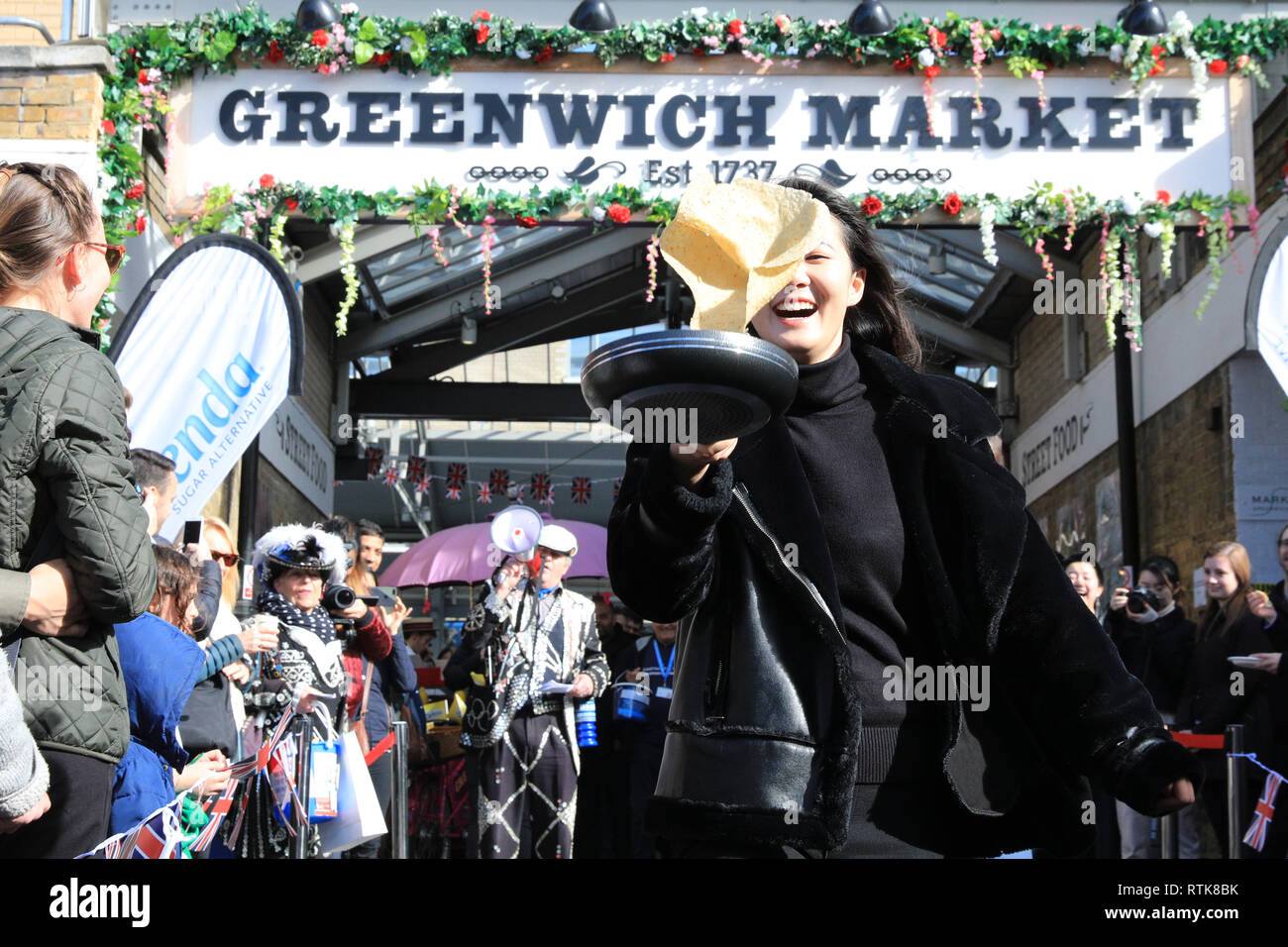 Greenwich, Londra, Regno Unito, 2 Mar 2019. I concorrenti hanno divertimento partecipa all'annuale gara di pancake. Il London pancake gara stagionale diventa di un flippin' buon inizio con la prima delle due pancake annuali gare al mercato di Greenwich oggi e il Martedì Grasso. La manifestazione tradizionale nel Royal Borough raccoglie fondi per il Greenwich e Bexley Comunità Ospizio. Credito: Imageplotter/Alamy Live News Foto Stock