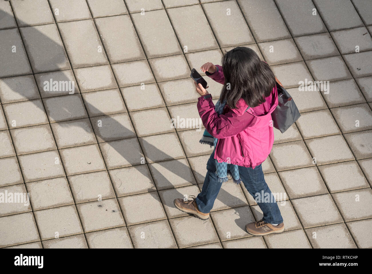 Donna che guarda al telefono cellulare mentre si cammina, Portland, Oregon. Foto Stock