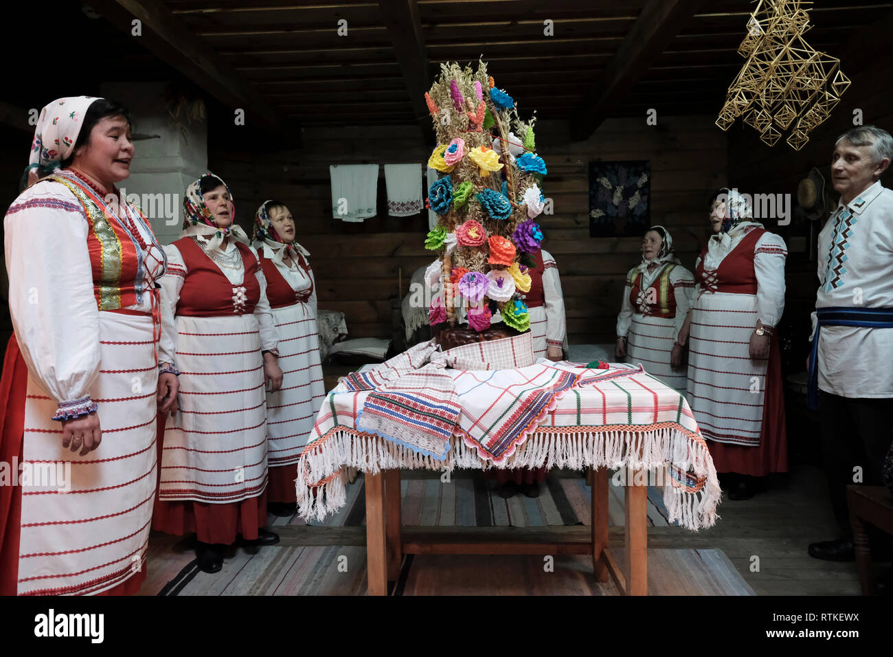 Il popolo bielorusso in abito tradizionale cantare canzoni folk intorno a un tradizionale matrimonio decorate pane durante la rievocazione di un tradizionale matrimonio bielorusso all'interno del Motal Folk Arts Museum di Motol o Motal una township di Ivanava Raion della regione di Brest Foto Stock