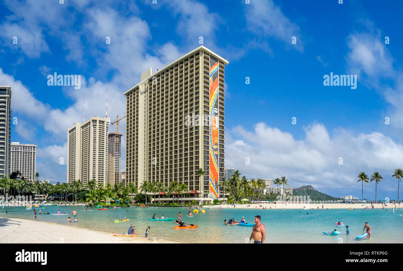 Gli amanti del sole sulla spiaggia di Waikiki all'Hilton Hawaiian il 7 agosto 2016 a Honolulu, Stati Uniti d'America. La spiaggia di Waikiki si trova quartiere di Honolulu, meglio conosciuta per il bianco Foto Stock
