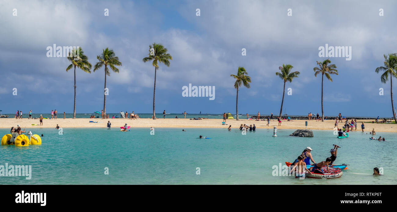 Gli amanti del sole sulla spiaggia di Waikiki all'Hilton Hawaiian il 7 agosto 2016 a Honolulu, Stati Uniti d'America. La spiaggia di Waikiki si trova quartiere di Honolulu, meglio conosciuta per il bianco Foto Stock