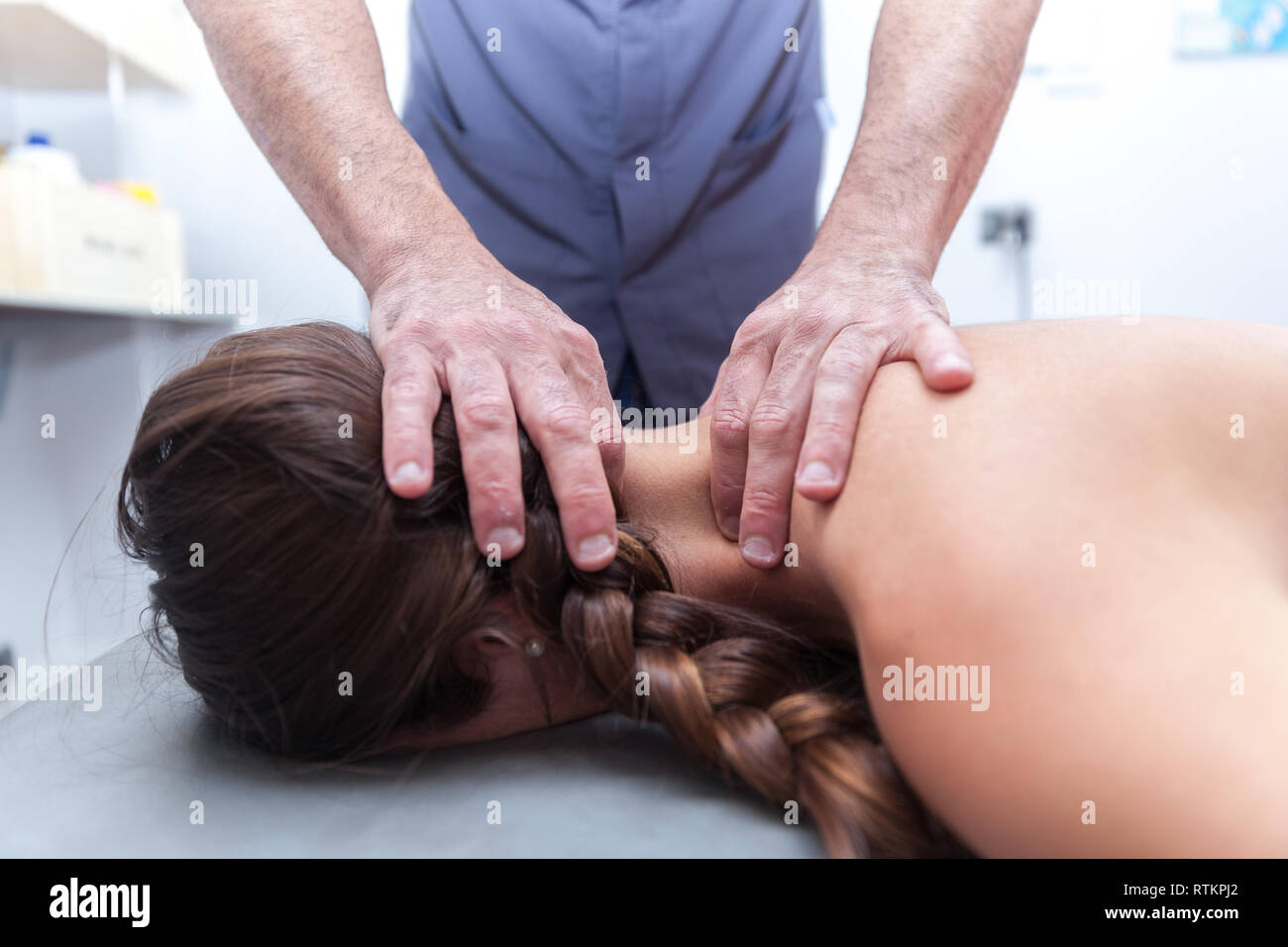 Fisioterapista trattare un giovane paziente femmina Foto Stock