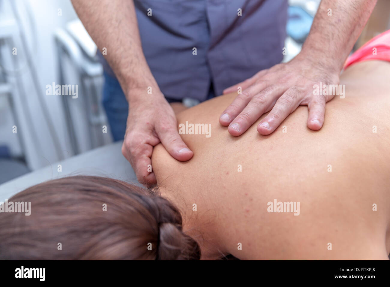 Fisioterapista trattare un giovane paziente femmina Foto Stock