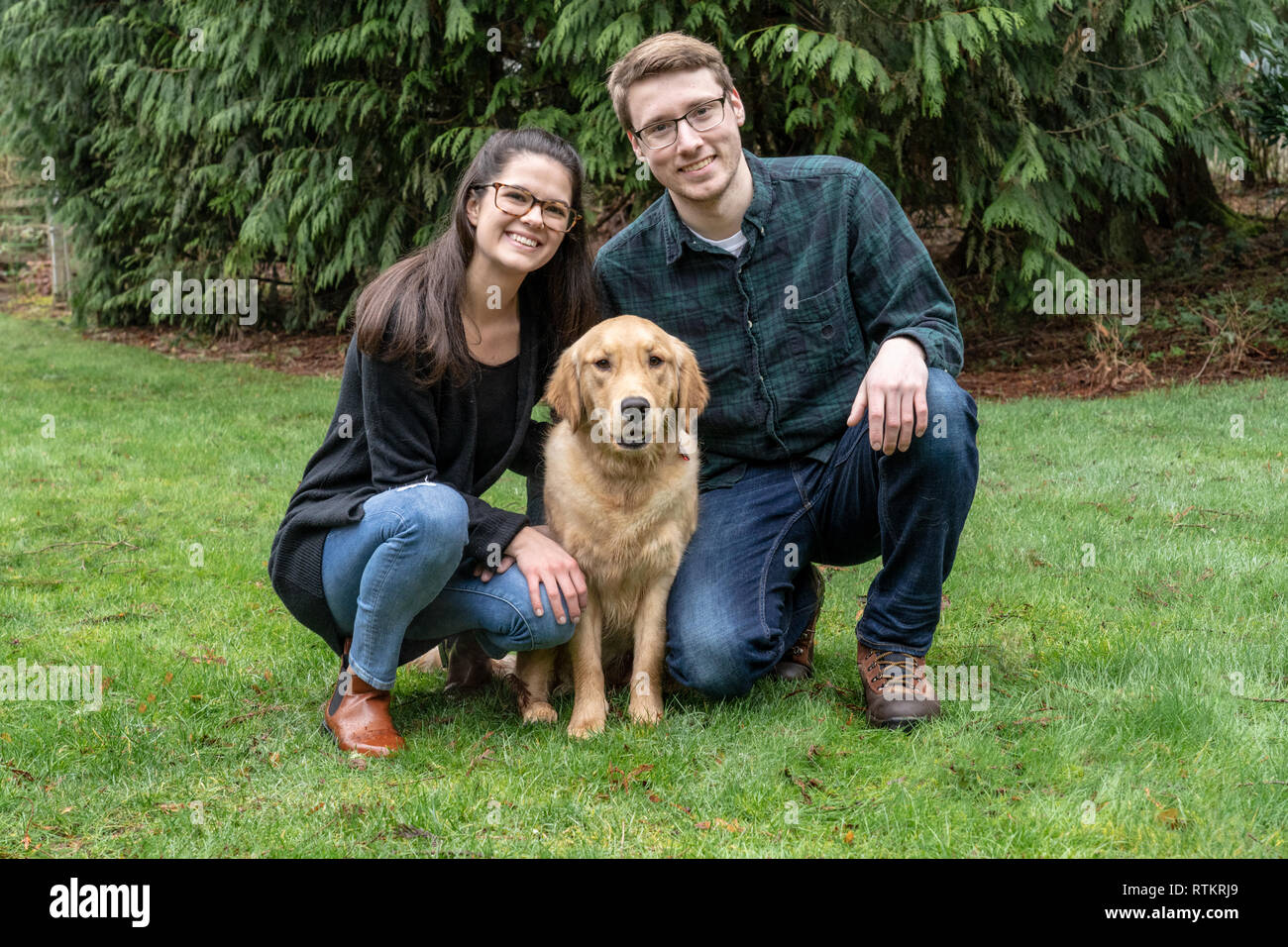 Issaquah, Washington, Stati Uniti d'America. Ritratto di nove mesi Golden Retriever 'Aspen' con i suoi proprietari. (PR) (MR) Foto Stock