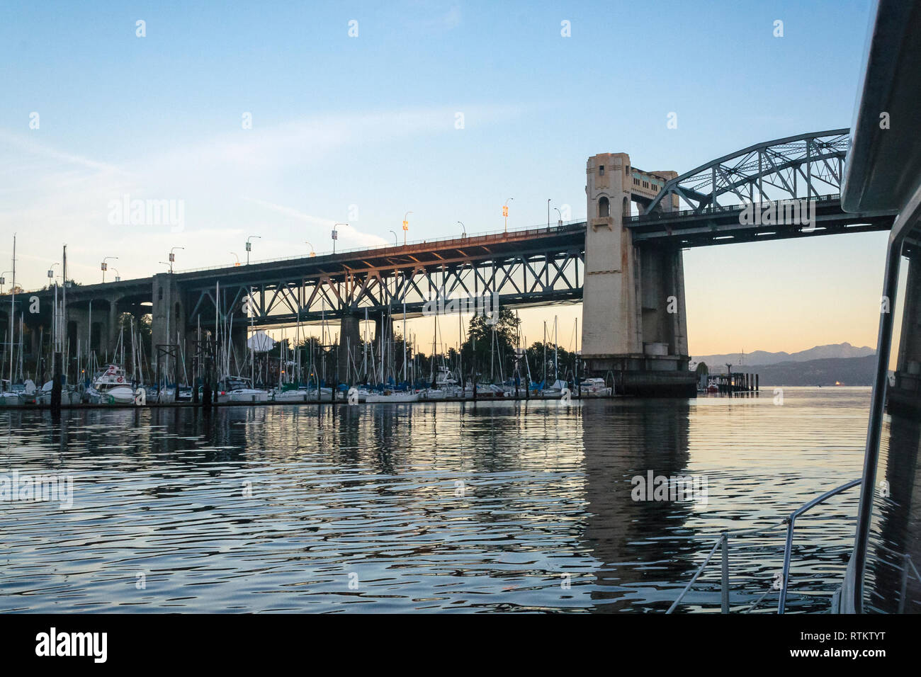 Una vista di False Creek e il Burrard Street Bridge all'alba, a bordo di una barca che sta per passare sotto il ponte a suo modo al mare da Vancouver. Foto Stock