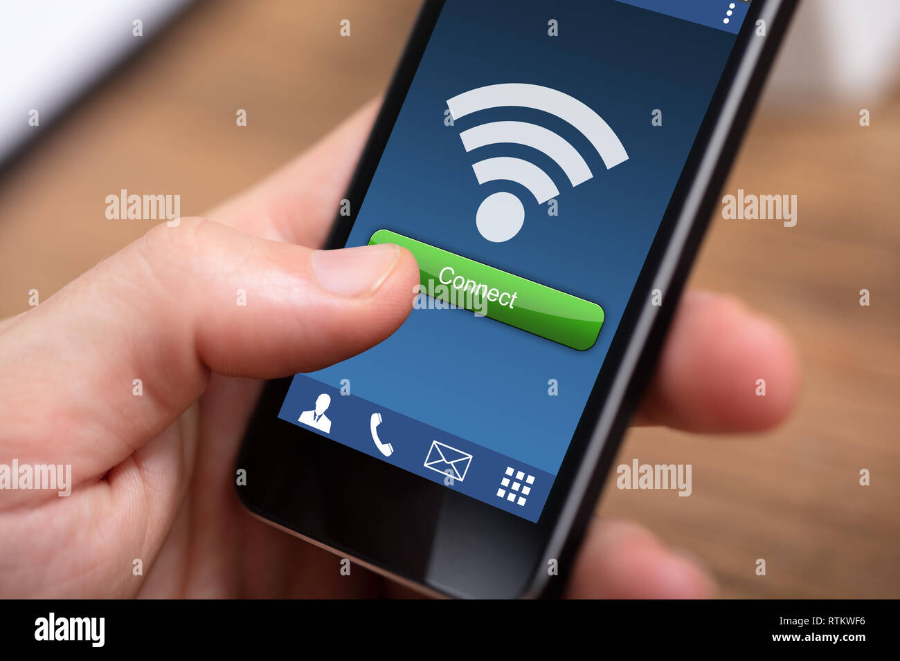 Close-up di persona della mano che tiene il telefono cellulare con la connessione wireless con connessione wireless Foto Stock