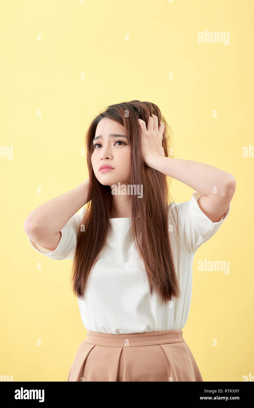 Giovane donna asiatica spazzolare i capelli e deludente condizione i suoi capelli Foto Stock