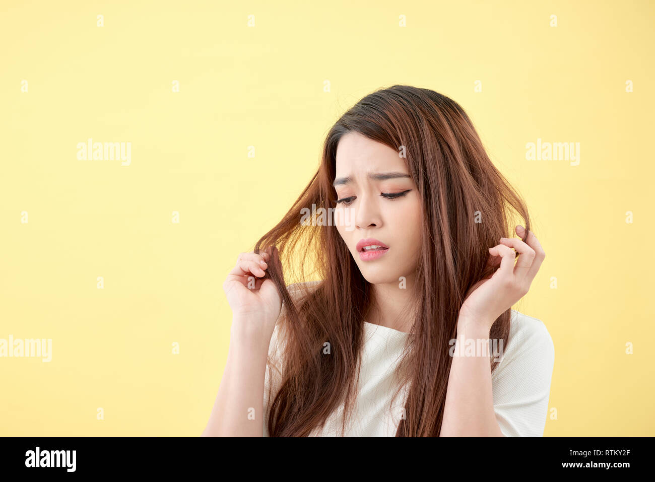 Giovane donna asiatica spazzolare i capelli e deludente condizione i suoi capelli Foto Stock