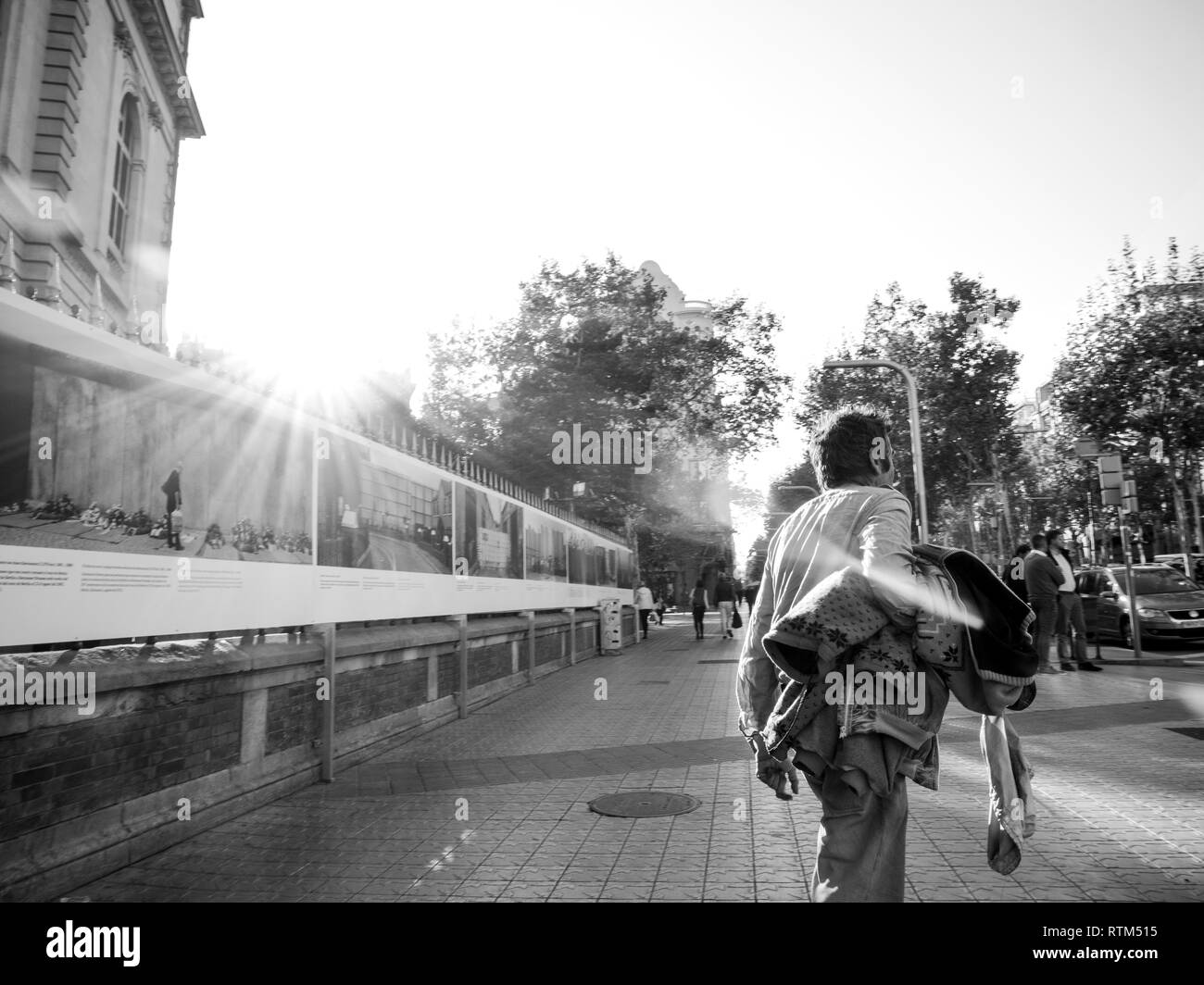 Barcellona, Spagna - Nov 17, 2017: giovane uomo davanti a 'con la frontiera' mostra sulle strade di Barcellona con fotografie di Kai Wiedenhofer sulle pareti di separazione nel mondo e la migrazione Foto Stock