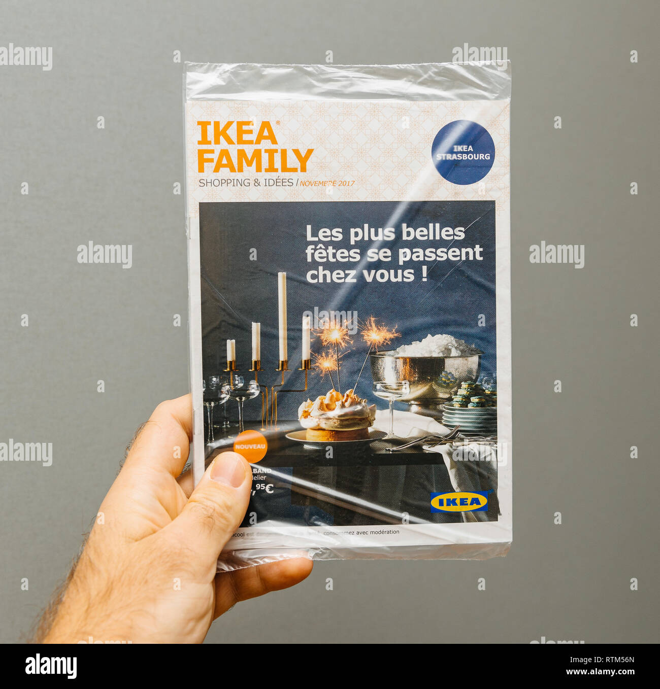 Parigi, Francia - Nov 19, 2017: Famiglia Ikea pubblicità newsletter in mano maschio contro uno sfondo grigio - propone vacanze di Natale idee shopping Foto Stock