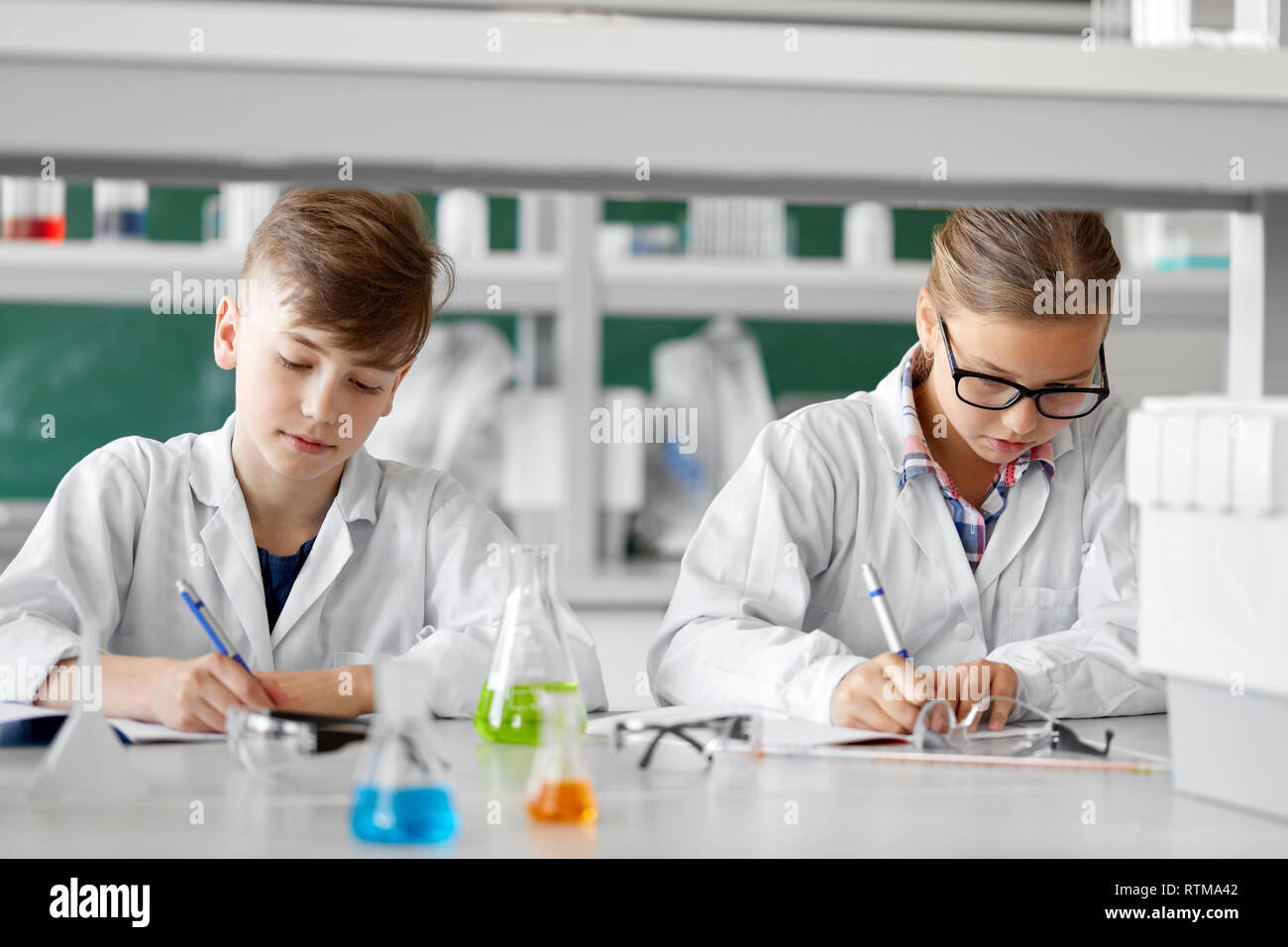 I ragazzi che studiano la chimica in laboratorio scolastico Foto Stock