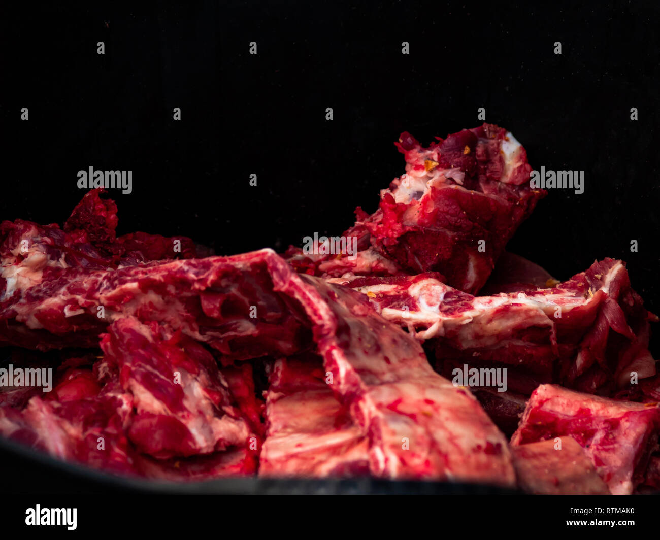Una carne di maiale cruda costola isolato con sfondo nero Foto Stock