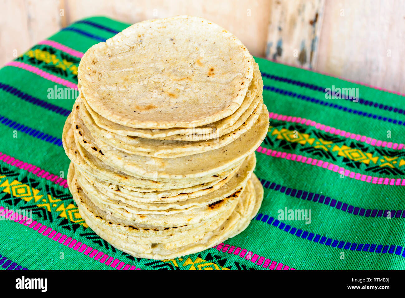 Pila di tradizionale a mano guatemalteco tortilla di mais un cibo di graffa in Guatemala il verde listati intrecciato la tovaglia Foto Stock