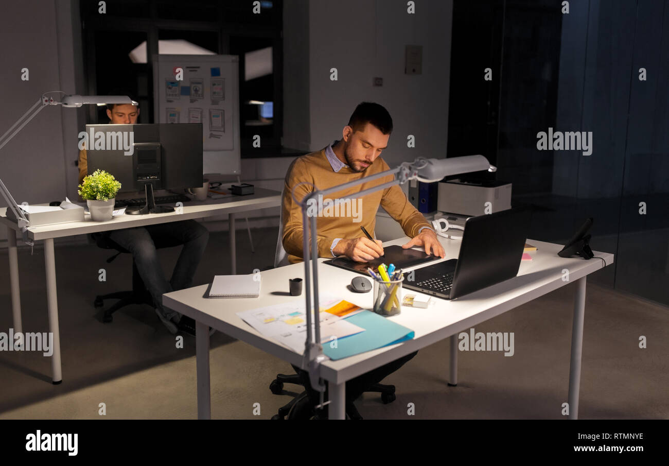 Uomo o designer con computer e tablet in ufficio Foto Stock