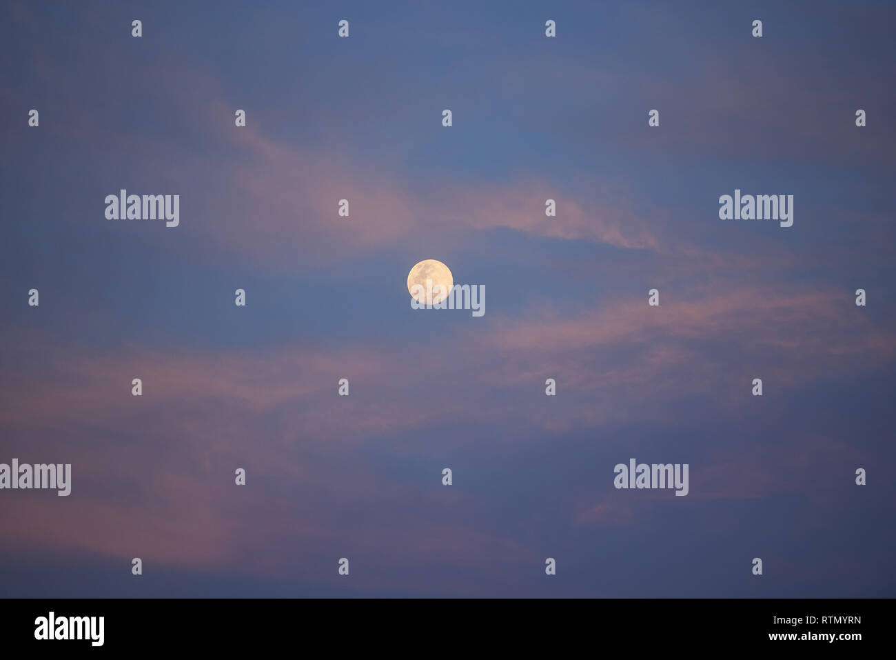 Luna piena sul Cielo di tramonto. Skyscape blu con nuvole rosa Foto Stock